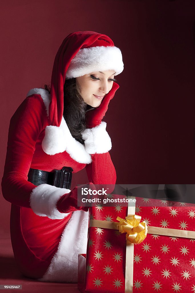 Lindo Natal brunette em vestido abre presente. - Foto de stock de Aberto royalty-free