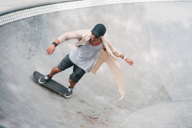istock young skater skating on longboard in pool at skatepark 954256370
