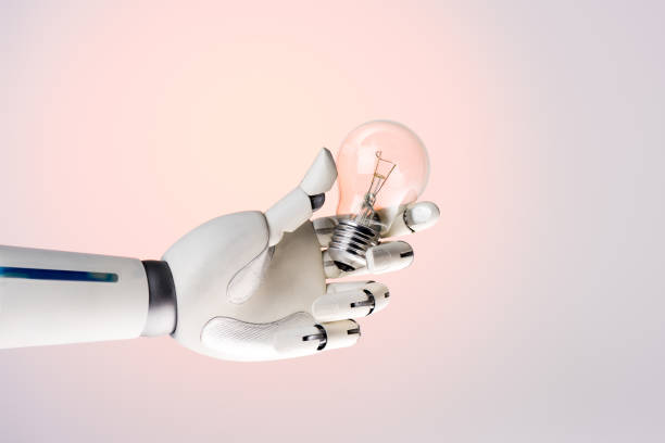 istock robot hand holding lamp isolated on beige 954260526