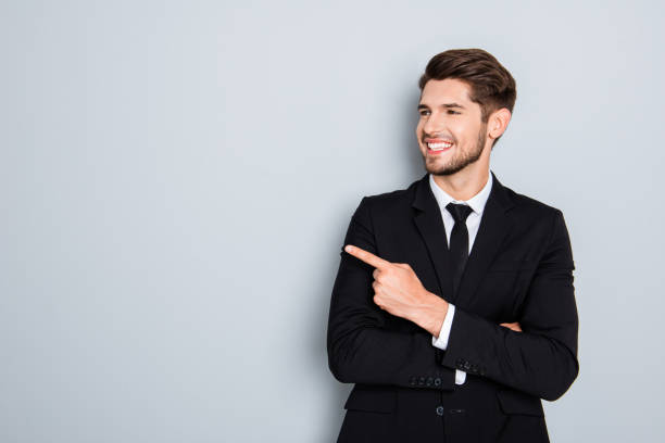 istock Happy handsome man showing way and pointing with finger 954260702