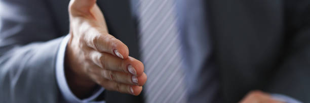 istock Man in suit and tie give hand as hello 954261234