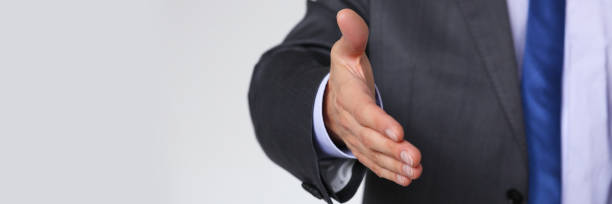 istock Man in suit and tie give hand as hello 954261324