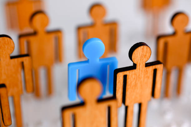 Little plastic blue toy figure stand out from unit crowd line closeup. One worker against odd hr job shift head hunter rare disease unit dismissal retire lgbt media virus epidemic success concept