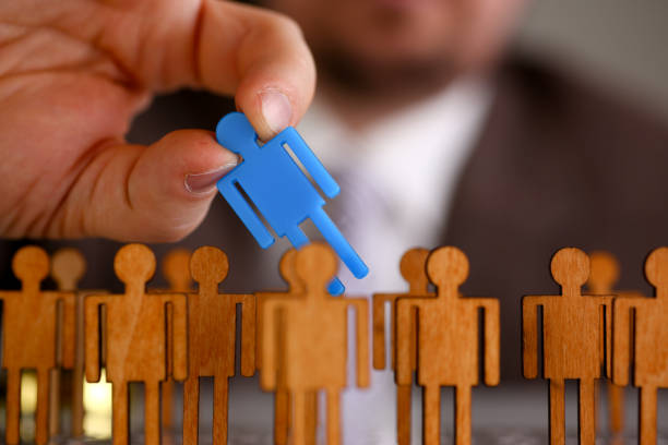 istock Man arm in suit take little plastic toy figure 954267580