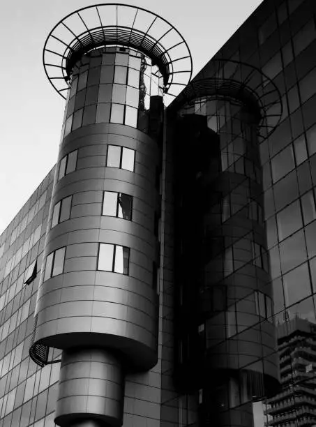 glass and aluminum turret feature architectural detail attached to office building with reflections in black and white