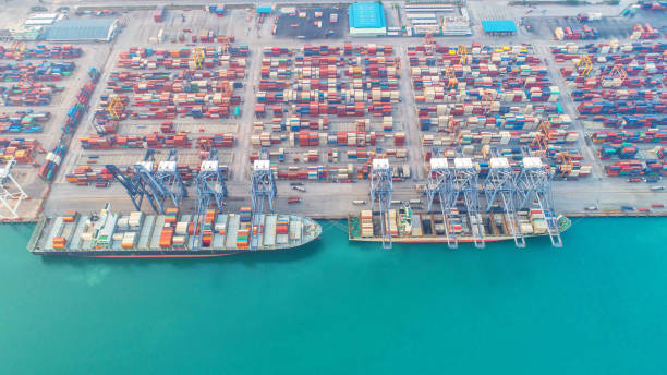 istock Container ship in export and import business and logistics. Shipping cargo to harbor by crane. Water transport International. Aerial view and top view 954271406