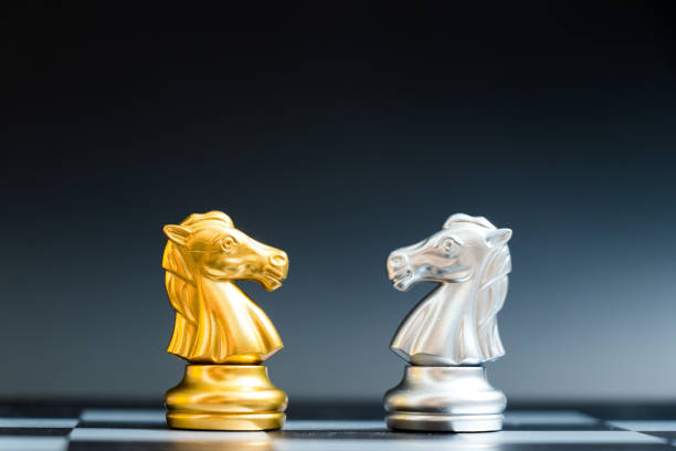 istock Gold and silver horse chess piece face in chessboard on black background 954275306