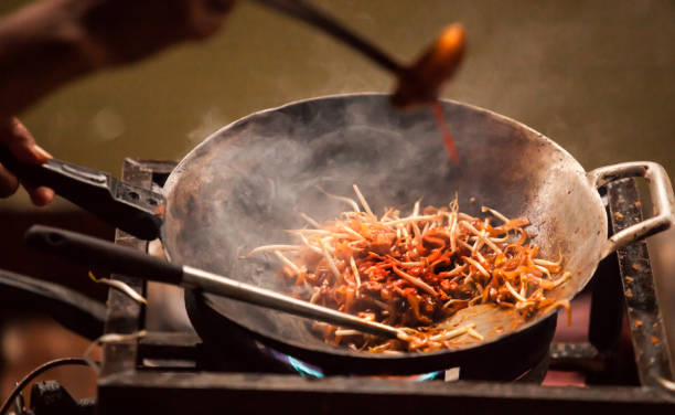 thai asian street fast food in padella calda, pad thai, o phad thai è un piatto di noodle di riso fritto mescolato comunemente servito come cibo di strada e nei ristoranti locali informali in thailandia. pad thai è uno dei menu gastronomici tailandesi pi - thailand thai culture thai cuisine pad thai foto e immagini stock