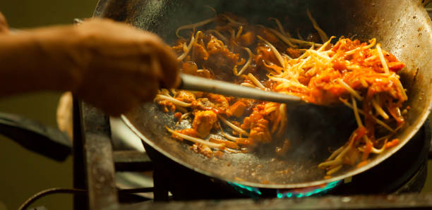 un de la restauration rapide asiatique thai rue plus préférée et les plus célèbre dans une poêle chaude, pad thai, est un plat de nouilles de riz frit sauté couramment servi comme une nourriture de rue et dans les restaurants les occasionnels en thaïlande. - thai cuisine photos et images de collection