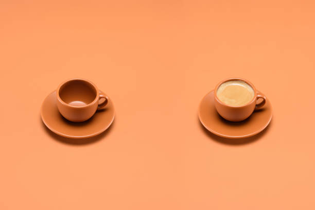 istock close up view of empty cup and cup of coffee isolated on peach 954311078