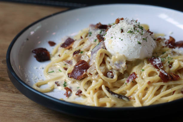 istock spaghetti carbonara with fried becon and egg on wooden table 954313758