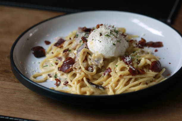 istock spaghetti carbonara with fried becon and egg on wooden table 954314242