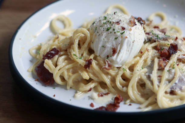 istock spaghetti carbonara with fried becon and egg on wooden table 954314354