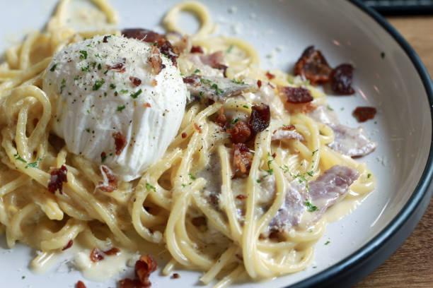 istock spaghetti carbonara with fried becon and egg on wooden table 954314380
