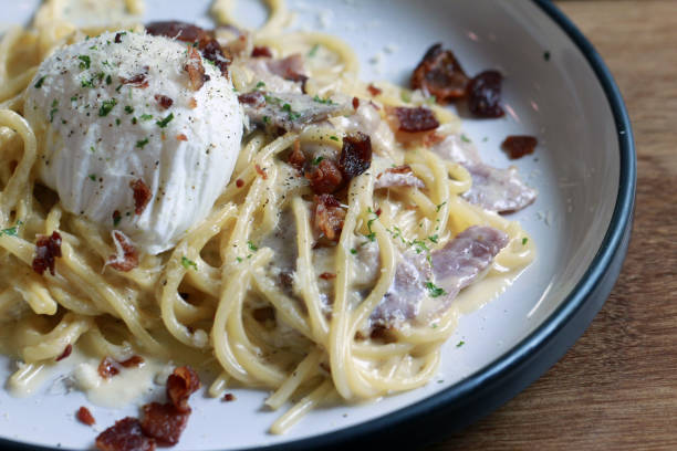 istock spaghetti carbonara with fried becon and egg on wooden table 954314460
