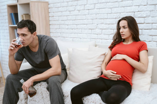istock A man drinks alcohol. Next to him is his pregnant wife. 954315362