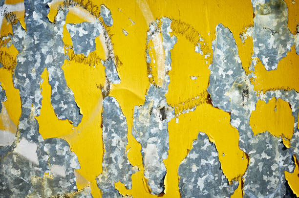 istock Weathered metal wall with peeling yellow paint. 954316464
