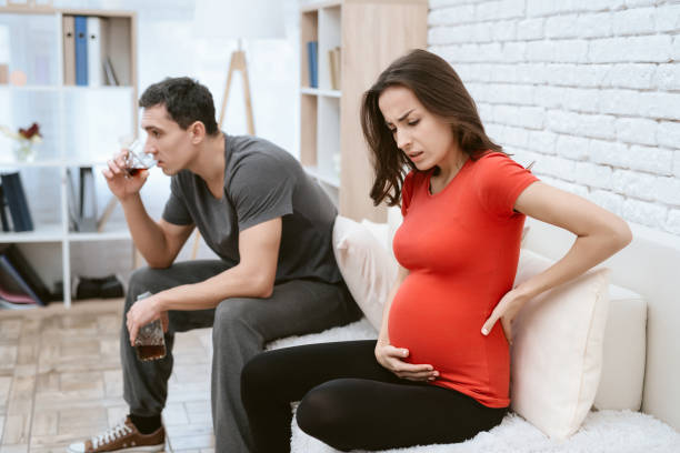 istock A man drinks alcohol. Next to him is his pregnant wife. 954317174