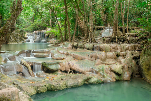 This is a horizontal color photograph of the lush landscape of Southeast Asia travel destination, Erawan Falls National Park in the Kanchanaburi province of Thailand. There are no people.