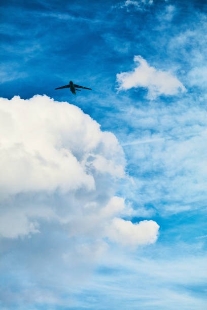 활기찬 푸른 하늘에 아름 다운 솜 털 구름을 통해 비행 하는 비행기 - vapor trail cirrus sky cloudscape 뉴스 사진 이미지