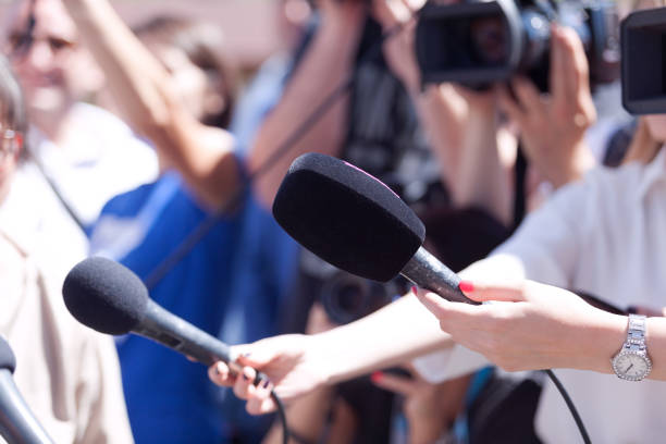 istock Journalists holding microphones at a media event. Reporters at work. 954329000