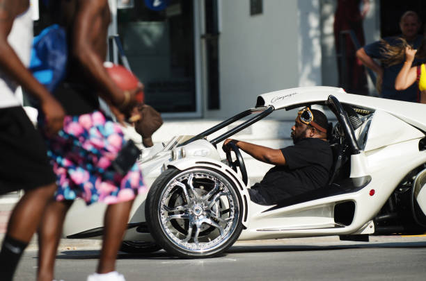 Miami - April 28, 2018: A young man rides in a flashy customized Campagna three-wheel motorcycle on Ocean Drive in South Beach.