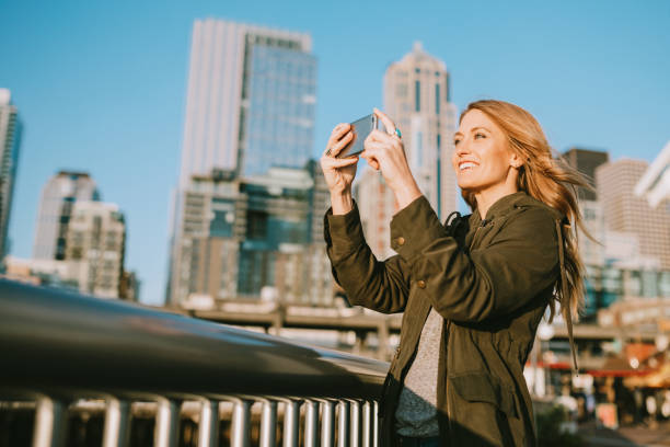 mujer toma imagen de teléfonos del centro de seattle - day washington state vertical outdoors fotografías e imágenes de stock