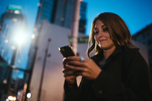 istock Woman Uses Smart Phone Downtown Seattle At Night 954334994