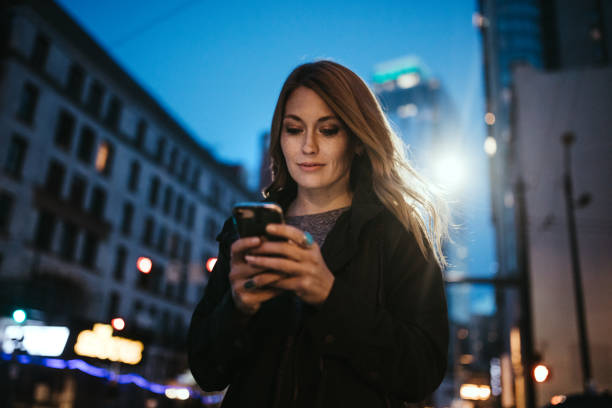 istock Woman Uses Smart Phone Downtown Seattle At Night 954335018