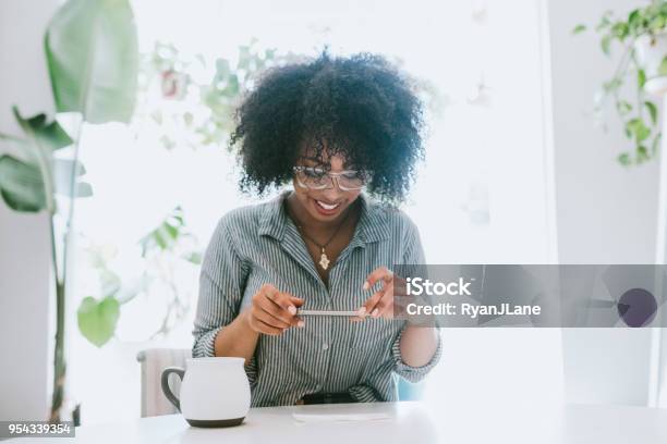 A Young Woman Does Remote Deposit Capture Of Check Stock Photo - Download Image Now - Down Payment, Bank Deposit Slip, Portable Information Device