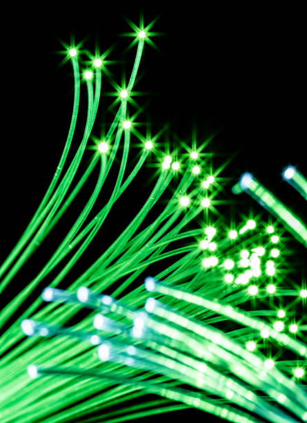 istock Bundle of optical fibers with green light. 954340428