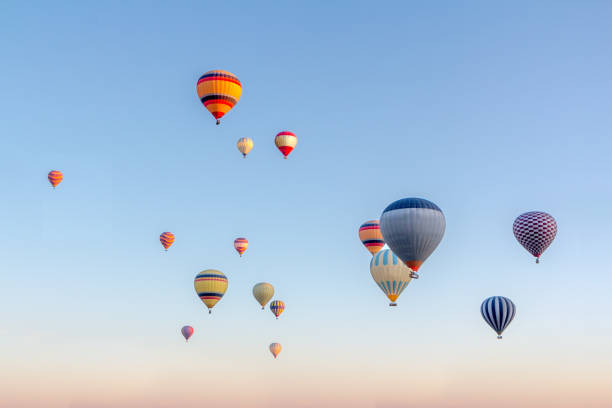 Bright multi-colored hot air balloons flying in sunsrise sky Cappadocia stock photo