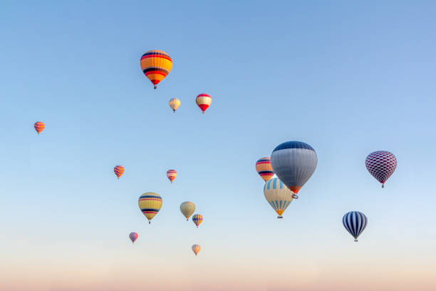 bright multi-colored hot air balloons flying in sunsrise sky cappadocia - hot air balloon landscape sunrise mountain imagens e fotografias de stock