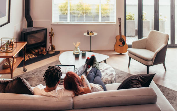 istock Couple sitting on sofa with laptop 954347096