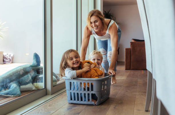 mutter mit ihren kindern zu hause spielen - playful mother playing daughter stock-fotos und bilder