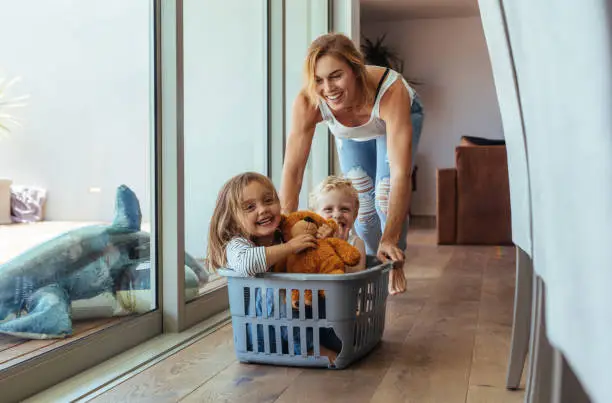 Photo of Mother playing with her children at home