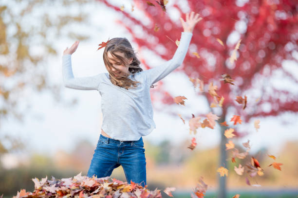 istock Girl having fun in leaf pile 954356858