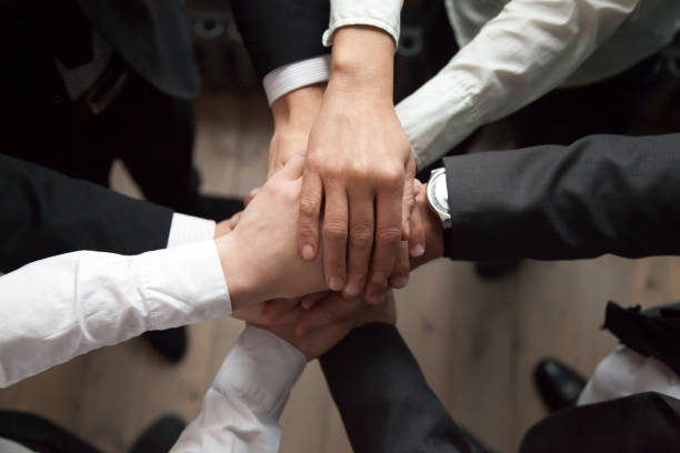 istock Motivated business people put hands together, trust and support concept 954357378
