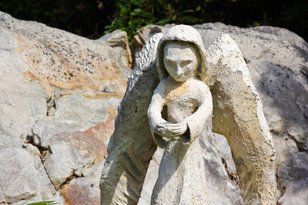 Generic cradling cement garden angel ornament on white quartz rock, South Africa
