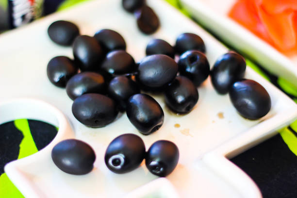 istock black olives on a white plate 954362702