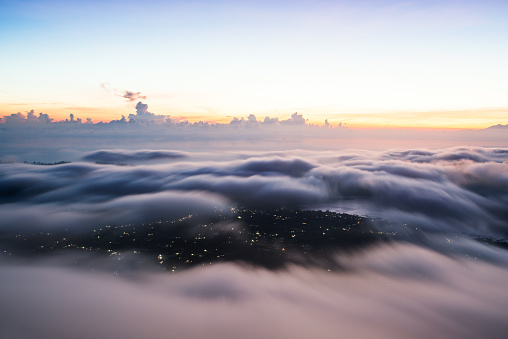 over the city, an aerial photo before dawn, clouds and lights of an early city