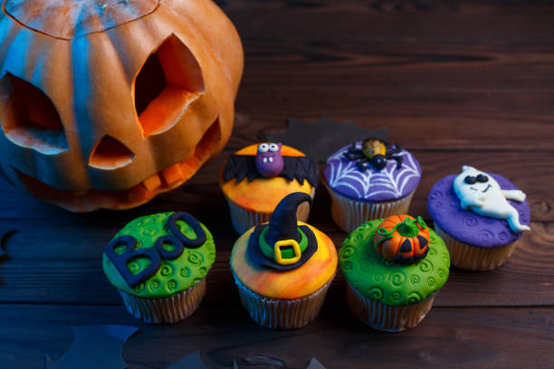 istock Tasty Halloween cupcakes set with colorful decorations: pumpkin, 954379136