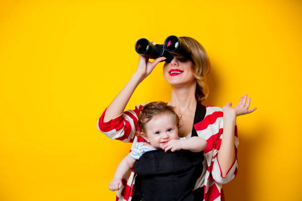 kleines baby carrier und mutter mit dem fernglas - baby beautiful little boys carrying stock-fotos und bilder