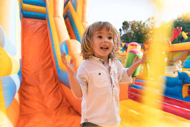 petit enfant s’amuser dans l’aire de jeux château gonflable - inflatable child playground leisure games photos et images de collection