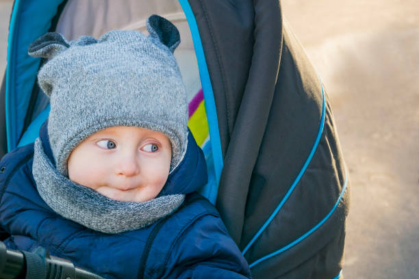 istock Little kid sitting on baby carriage 954392024