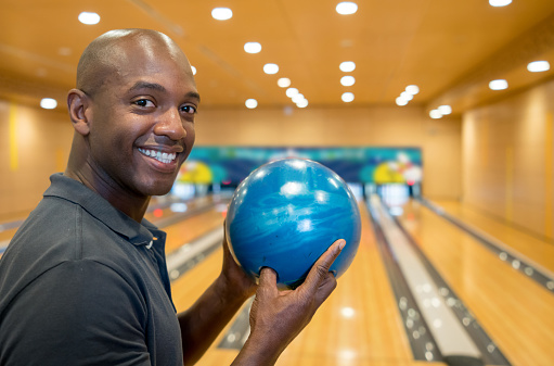 Portrait of black bowling player looking at camera very happy and smiling
