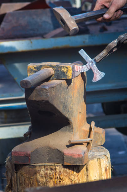istock blacksmith performs the forging of hot glowing metal on the anvil 954412018