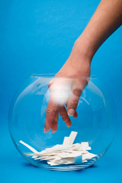 istock Hand in crystal bowl choosing a winning lottery ticket 95442272
