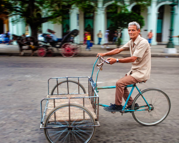 One Million Bikes (Havana, Cuba 2012) After the fall of the Soviet Union in 1991, petroleum and other subsidies dried up, bringing cars and public transport grinding to a standstill across the island. During this “Special Period”, as it was called by the government, to keep Cubans moving through years of extreme austerity, Fidel imported a million Chinese bikes and kicked off an unexpected cycling boom, along with bike lanes, spare parts shops, guarded parking and neighborhood mechanics. This barely lasted a decade, as ships carrying Venezuelan petroleum sailed into Havana harbor, courtesy of late President Hugo Chávez, who also offered interest-free loans to help the Cuban economy out of crisis and traded oil for Cuban doctors. Cycling eventually fell out of favor, with subsidies and spare parts drying up. If you ever have the opportunity to travel to Cuba, see if can spot some of those Chinese bikes! havana harbor photos stock pictures, royalty-free photos & images