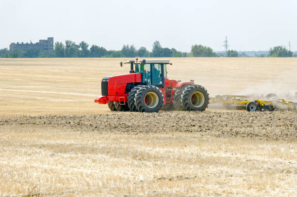 istock Tractor plowing field at summer 954424168